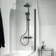 Schwarzes Duschsystem von Ideal Standard an der Wand montiert, mit Kopf- und Handbrause sowie einem transparenten Duschabtrennungselement. Minimalistische Badezimmergestaltung.